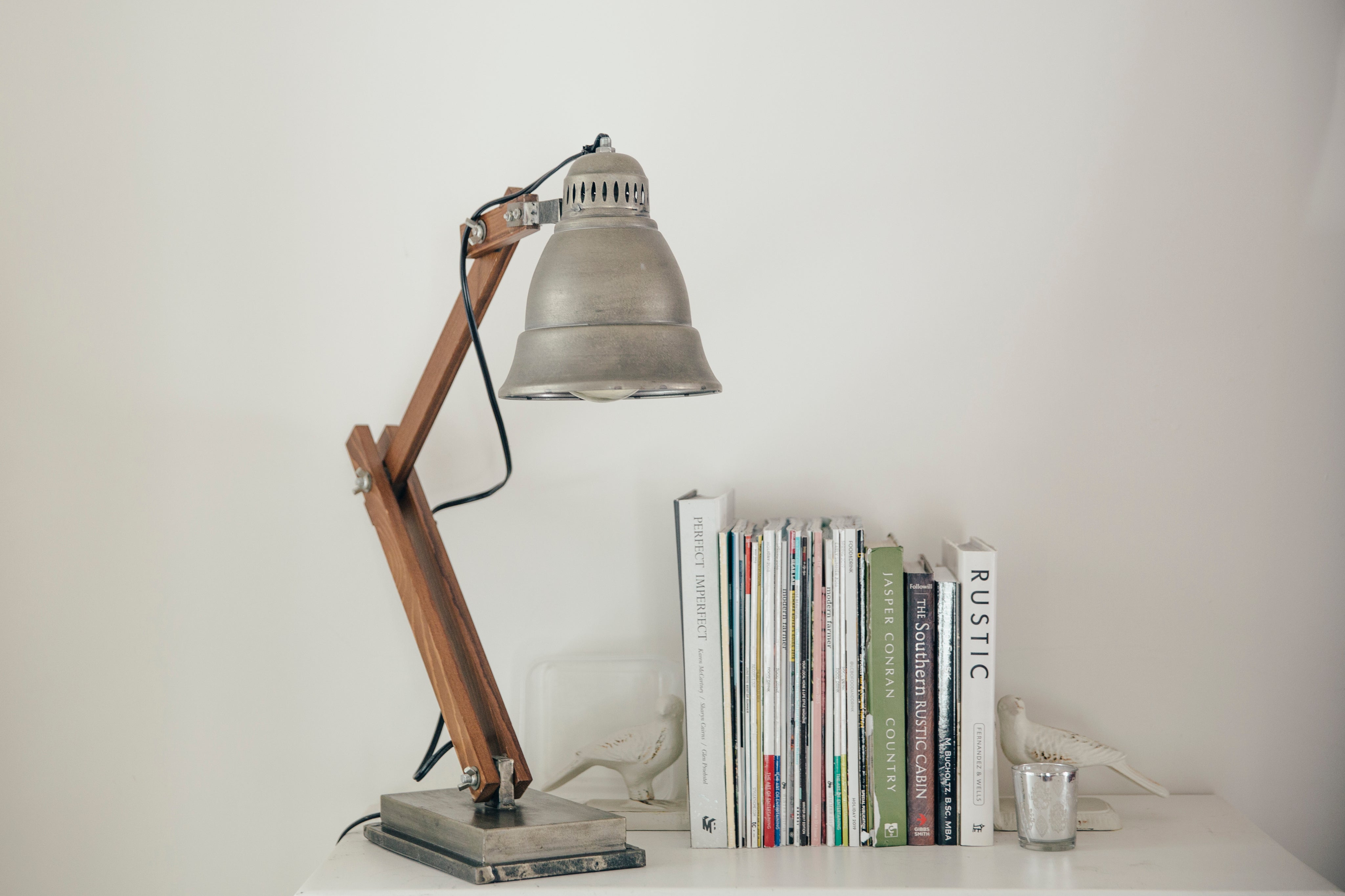 silver-lamp-on-a-white-table-next-to-books.jpg